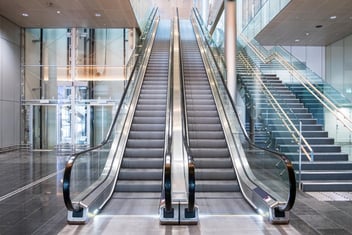 Two escalators side by side in a modern complex
