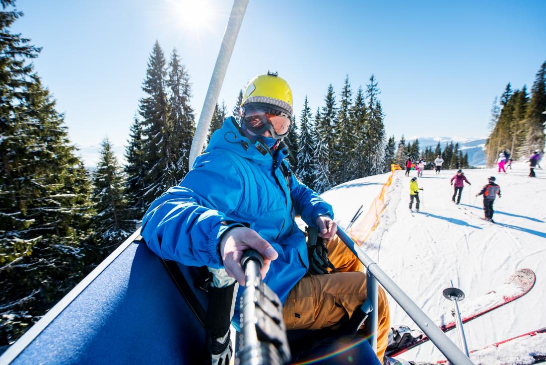 Person on chairlift taking photo with a selfie stick