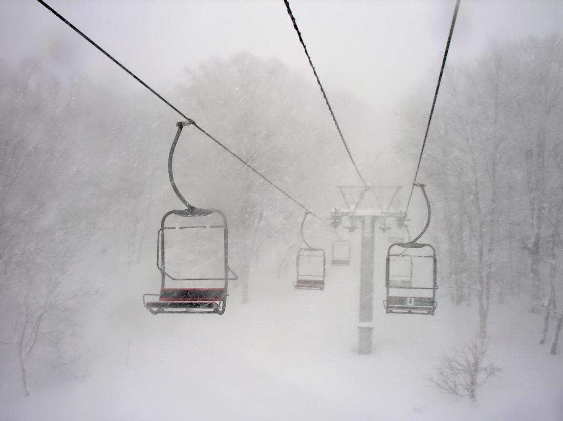 Empty chairlift in the snow and fog